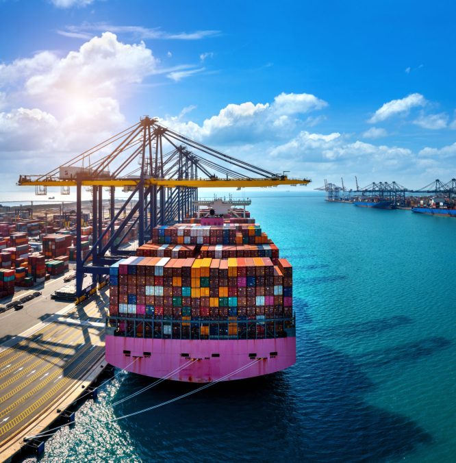 Aerial view of cargo ship and cargo container in harbor.